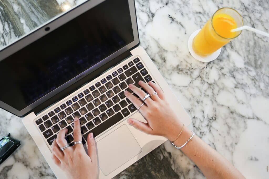 Business owner writing blog content on laptop in modern office — blogging for SEO and content marketing in 2025